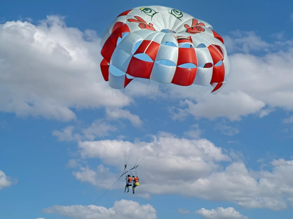 Parasailing canopy above the sea, illustrating boat-towed flight distinct from hill-launched paragliding