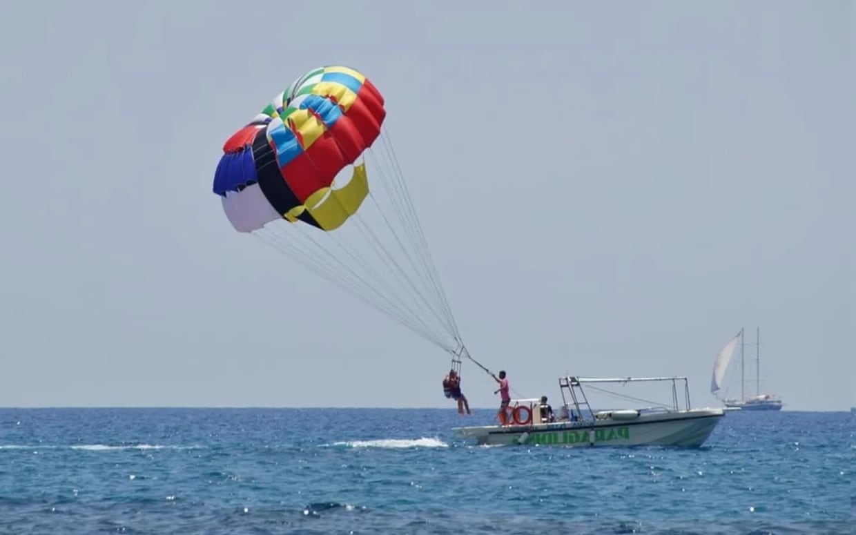 Parasailing canopy high above the sea, showing the height and weather-dependent beach setup